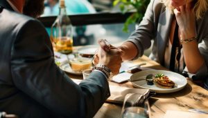 Investor discussing the terms of a personal loan for real estate financing with a family member at a cafe.